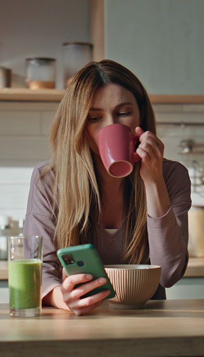 Frau beim Kaffeetrinken am Handy